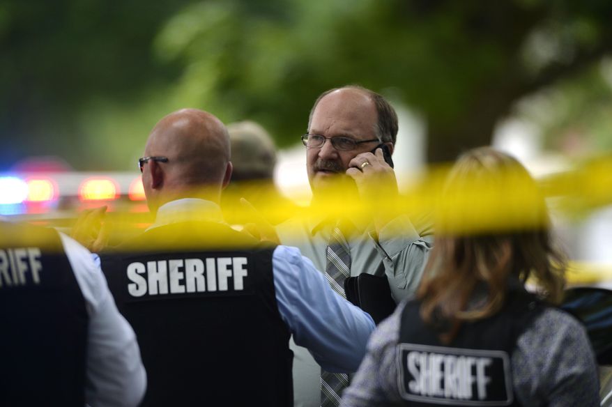 Police officials talk on the scene after a double stabbing on Wednesday, June 22, 2016, in Flint, Mich. (Rachel Woolf /The Flint Journal-MLive.com via AP) LOCAL TELEVISION OUT; LOCAL INTERNET OUT; MANDATORY CREDIT