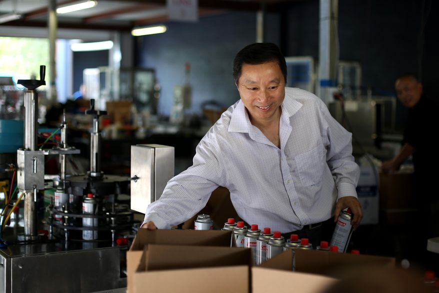 Jude Shao, CEO, fills orders of butane canisters, at American Energy Products Company, Friday, June 10, 2016, in Houston, Texas. American Energy manufactures butane canisters for Coleman and Sky Blue, their own brand name. Shao spent a decade in a Chinese prison, uncertain when he'd be let go, and then was barred from leaving Shanghai for five more years. ( Gary Coronado/Houston Chronicle via AP) MANDATORY CREDIT