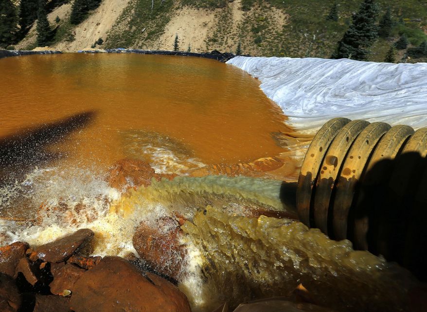 In this Aug. 14, 2015, file photo, water flows through a series of sediment retention ponds built to reduce heavy metal and chemical contaminants from the Gold King Mine wastewater accident, in the spillway downstream from the mine, outside Silverton, Colo. New Mexico is suing the state of Colorado, saying its neighbor to the north should be held responsible for the contamination caused by the 2015 Gold King Mine spill as well as decades of toxic drainage from mines near the headwaters of the Animas River. (AP Photo/Brennan Linsley, File)