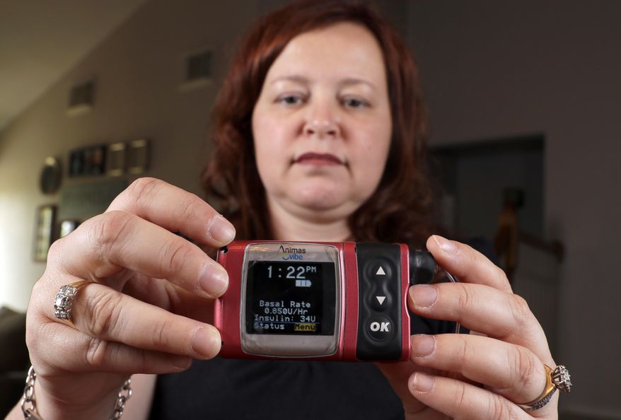 In this Tuesday, June 7, 2016, photo, Stephanie Rodenberg-Lewis holds her Animas Corp. insulin pump at her home in Katy, Texas. Her insurance company, UnitedHealth Group Inc., has made a deal with device maker Medtronic that will slash options for diabetics who use the wearable pumps which cost thousands of dollars. (AP Photo/David J. Phillip)