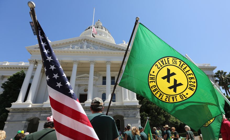 The flag of the United States flutters in the wind along side a flag showing the double XX, representing the state of Jefferson during a Capitol rally attended by dozens of residents from several rural counties calling for the creation of the state of Jefferson, Thursday, Aug. 28, 2014, in Sacramento, Calif. Representatives from two counties in far Northern California are petitioning lawmakers for the right to form the 51st state, to be called Jefferson.(AP Photo/Rich Pedroncelli)