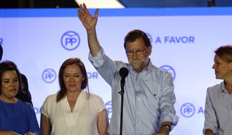 Spain&#39;s acting Prime Minister and candidate of Popular Party Mariano Rajoy waves to his supporters next to his party members as they celebrate the results of their party during the national elections in Madrid, Spain, Sunday, June 26, 2016. (AP Photo/Daniel Ochoa de Olza)
