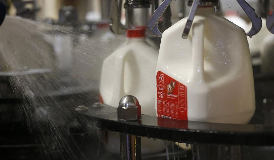 In this Tuesday, June 14, 2016, file photo, bottles of whole milk are rinsed off as they go through the production line at the Anderson Erickson milk plant in Des Moines, Iowa. Two percent and whole milk sales have climbed, while fat-free milk demand has declined. (Michael Zamora/The Des Moines Register via AP)  ** FILE **