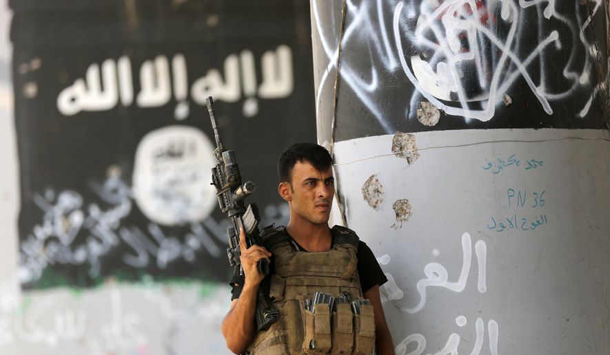 A member of Iraqi counterterrorism forces stands guard near Islamic State militant graffiti in Fallujah, Iraq, Monday, June 27, 2016. Thick clouds of black smoke billowed over northwest Fallujah Monday as dozens of homes continued to burn a day after the city was declared “fully liberated” from the Islamic State group. Iraqi special forces Lt. Gen. Abdel Wahab al-Saadi who led the operation to retake the city, said that IS militants torched hundreds of houses in Fallujah&#x27;s north and west as they fled Sunday, just as the fighters did in many of the city&#x27;s other neighborhoods over the course of the operation. (AP Photo/Hadi Mizban)