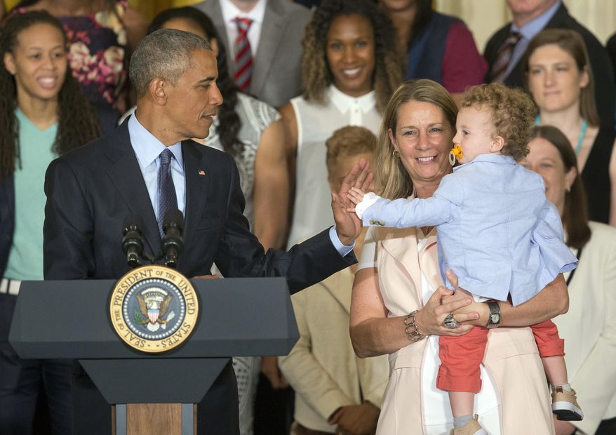 President Barack Obama, left, gets a high five from Oliver, son of Minnesota Lynx head coach Cheryl Reeve, right, in the East Room of the White House in Washington, Monday, June 27, 2016, during a ceremony where he honored the 2015 WNBA basketball Champion Minnesota Lynx. (AP Photo/Pablo Martinez Monsivais)