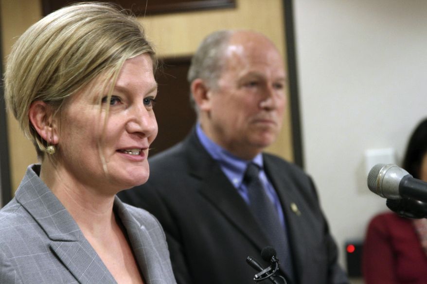 Jahna Lindemuth, left, is introduced Tuesday, June 28, 2016, in Anchorage, Alaska, as the state's new attorney general. Gov. Bill Walker, right, made the announcement at a news conference. (AP Photo/Mark Thiessen)