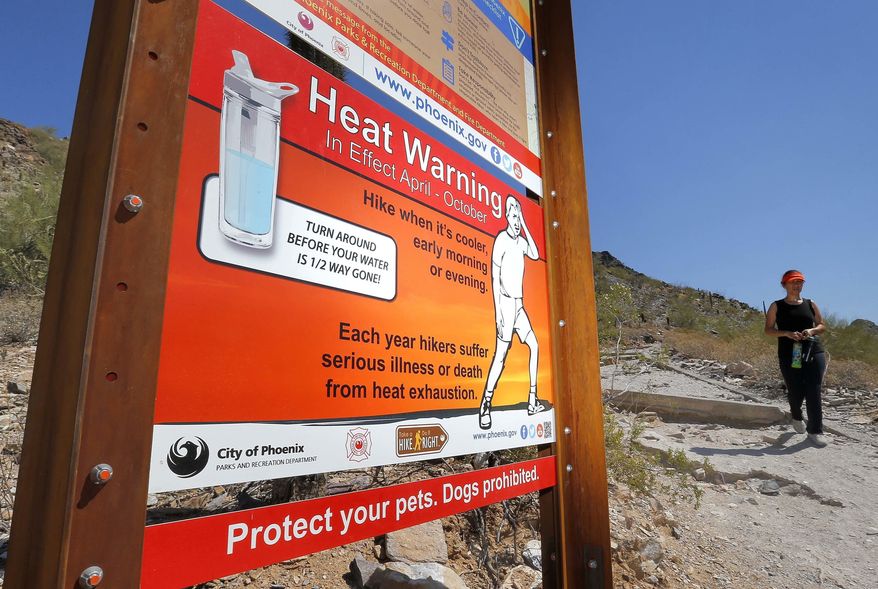 FILE - In this June 22, 2016 file photo, a sign warning of extreme heat is seen on a trailhead at Piestewa Peak in Phoenix. Thirty-one of the country’s top science organizations are telling Congress that global warming is real, a problem and something needs to be done about it. The science groups, which represent millions of scientists, sent the letter Tuesday, June 28, 2016, saying the severity of climate change is increasing and will get worse faster in coming decades. (AP Photo/Matt York, File)