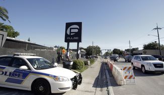 FILE - In this June 22, 2016, file photo, traffic moves along Orange Avenue after authorities opened the streets around the Pulse nightclub, scene of a recent mass shooting in Orlando, Fla. Police dispatchers heard repeated gunfire, screaming and moaning from patrons of the Pulse nightclub who called to report that gunman Omar Mateen was opening fire inside the club, according to written logs released Tuesday, June 28, 2016. (AP Photo/John Raoux, File)