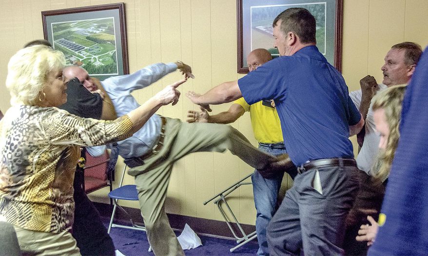 Alexander City, Ala Mayor Charles Shaw, left, is restrained by an officer after a fight broke out between him and councilman Tony Goss, far right, during a meeting of the Alexander City City Council in Alexander City, Ala. on Monday, April 25, 2016. Shaw has been found guilty of assault in an attack on a councilman during a meeting in late April. Court records filed Wednesday, June 29, 2016, say Shaw was convicted of third degree assault in Tallapoosa County District Court. (Mitch Sneed/Alexander City Outlook via AP)