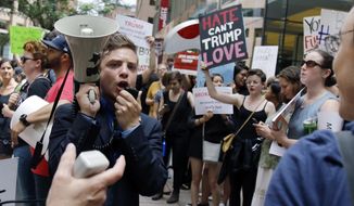 Protestors chant outside a downtown hotel in Boston, Wednesday, June 29, 2016, where Republican presidential candidate Donald Trump was holding a lunchtime fundraiser. Trump was scheduled to hold a rally later in the afternoon in Bangor, Maine. (AP Photo/Bill Sikes)