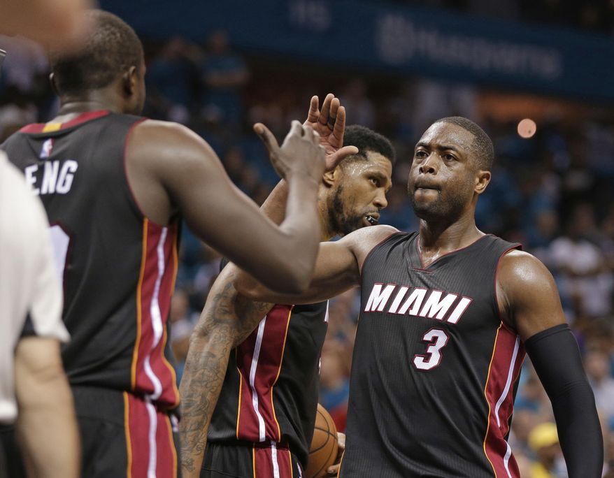 FILE - In this April 29, 2016, file photo, Miami Heat's Dwyane Wade (3) gives a high-five to Luol Deng after Game 6 of an NBA basketball playoffs first-round series against the Charlotte Hornets in Charlotte, N.C. Wade still has every hope of finishing his NBA career in the same manner that it began, wearing a Heat uniform. That's the good news for Heat fans. Now comes the tough part, that being Wade and the team figuring out how to make that a reality. (AP Photo/Chuck Burton, File)