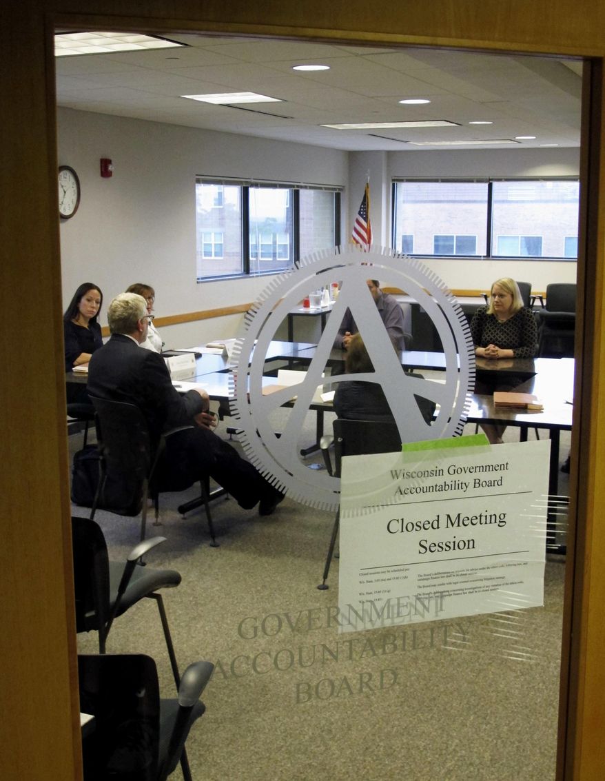 FILE - In this June 9, 2016, file photo, members of the newly created Wisconsin Ethics Commission meet in closed session with staff of the Government Accountability Board in Madison, Wis. The GAB officially disbands on Thursday, June 30, 2016, after eight years of operation. In its place will be two commissions with partisan appointees. One will oversee elections while the other handles ethics, campaign finance and lobbying laws. (AP Photo/Scott Bauer, File)