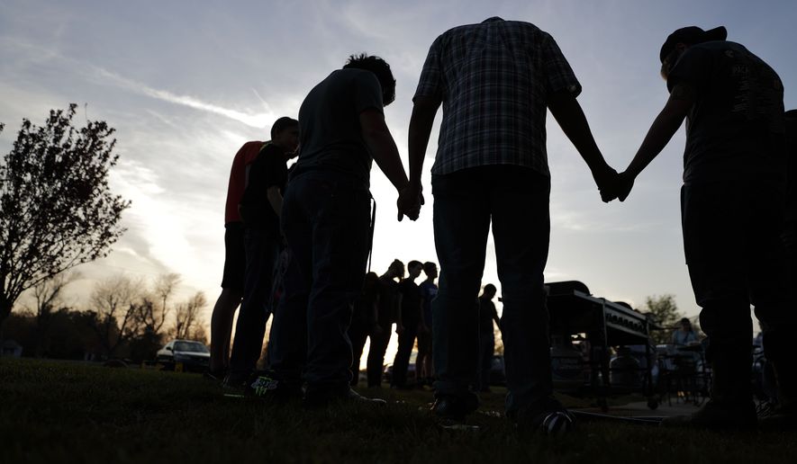 In this Sunday, April 10, 2016, file photo, youths hold hands for a prayer during a gathering at sunset outside the Christian Fellowship Church in Benton, Ky. (AP Photo/David Goldman) ** FILE **