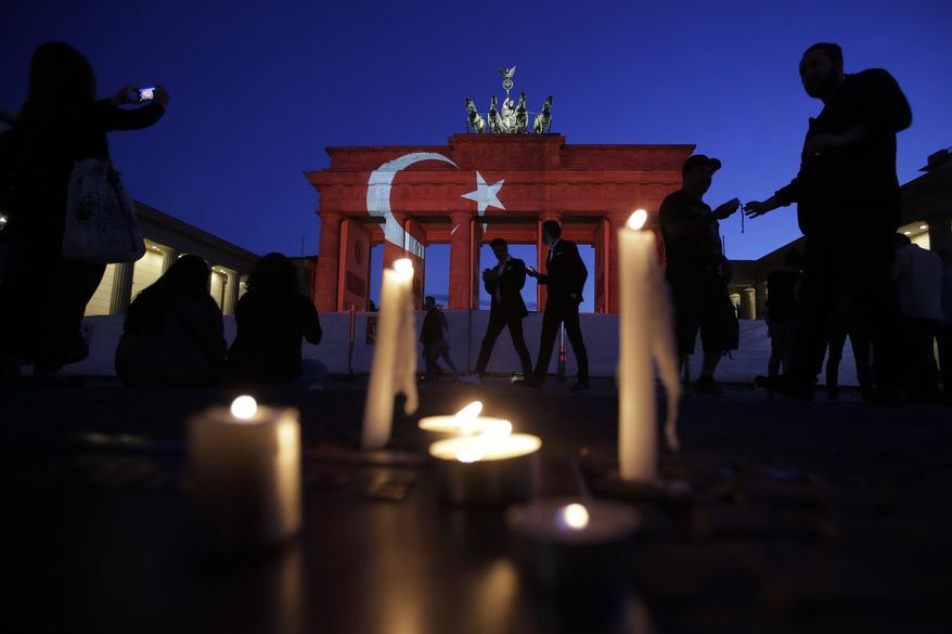Candles are placed in front the Brandenburg Gate in Berlin, Wednesday, June 29, 2016. The Brandenburg Gate was illuminated with Turkey's national flag after suicide attackers killed dozens and wounded more than 140 at Istanbul's busy Ataturk Airport late Tuesday, the latest in a series of bombings to strike Turkey in recent months. (AP Photo/Markus Schreiber)