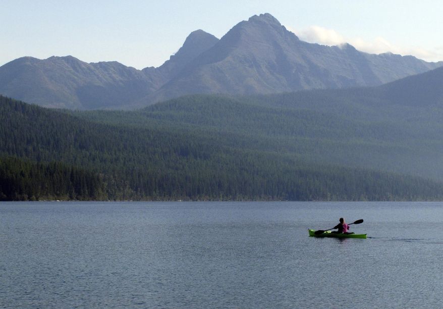 In this Sept. 6, 2013, file photo, a woman kayaks on Kintla Lake in Glacier National Park, Mont. A grizzly bear attacked and killed a 38-year-old mountain biker Wednesday, June 29, 2016, as he was riding along a trail just outside the national park, Montana authorities said. (AP Photo/Matt Volz, File)