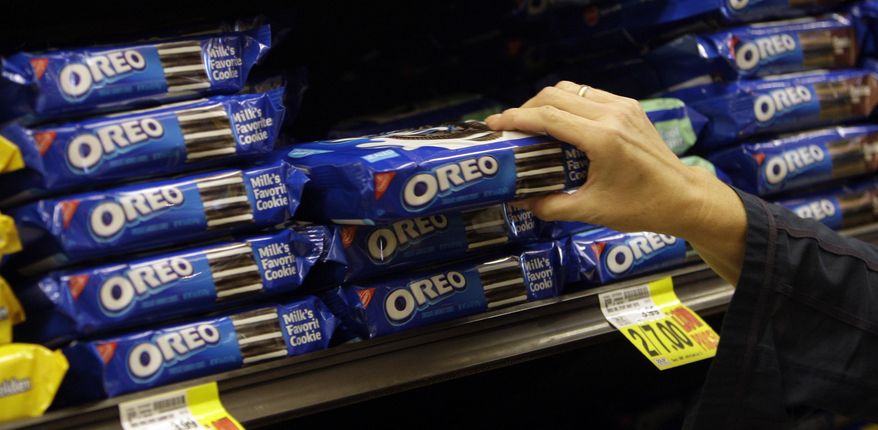 FILE - In this Feb. 9, 2011, file photo, a shopper selects Oreo cookies at a Ralphs Fresh Fare supermarket in Los Angeles. Shares of Hershey are soaring Thursday, June 30, 2016, after a report that it could be taken over by Oreo cookie maker Mondelez International. (AP Photo/File)