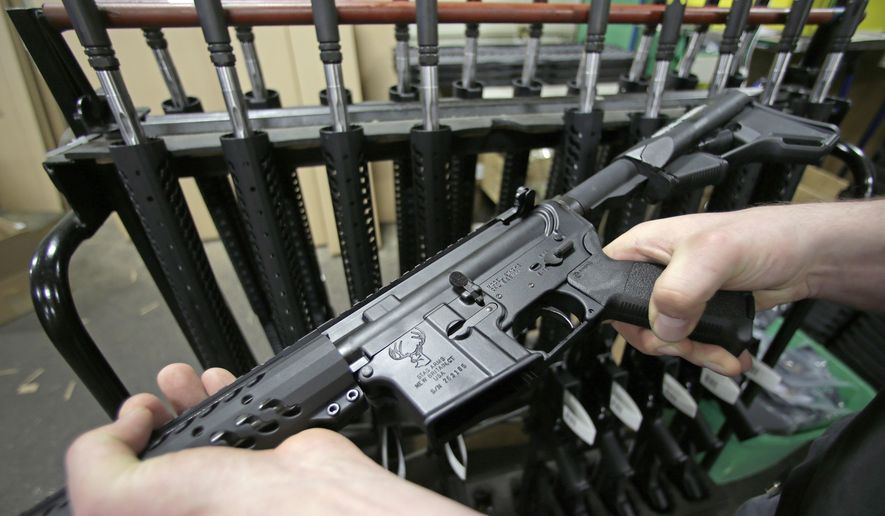 In this April 10, 2013, file photo, a man holds a newly-assembled AR-15 rifle in New Britain, Conn. (AP Photo/Charles Krupa, File)