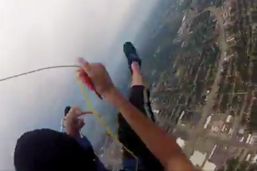 In this frame grab shot from the the helmet cam of Daniel Herndon, shows Herndon after his parachute malfunctioned. He says the deployment bag come out spinning, causing a line twist in the parachute. The Skiatook, Okla., man says he struggled with the malfunctioning parachute for about 500 feet before he deployed his reserve canopy and managed to land on the stadium field. (Daniel Herndon via AP)