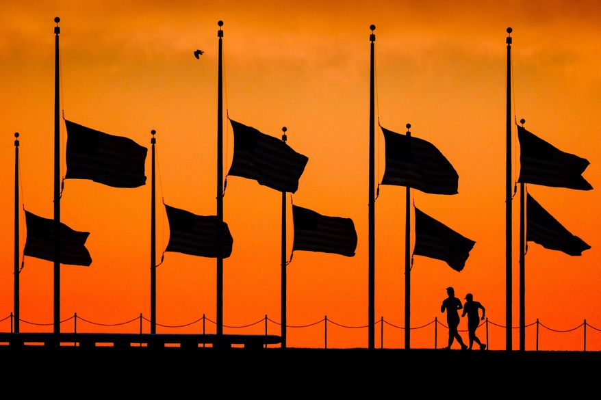 FILE - In this June 13, 2016 file photo, flags fly at half-staff around the Washington Monument at daybreak in Washington, by order of President Obama, the day after more than four dozen people were killed in the Orlando, Fla., nightclub shootings. As the nation marks Independence Day on Monday, lowering the flag remains a visible, immediate way to pay tribute in hours of tragedy, but flag buffs have noted that the honor has been extended more widely over time, and they and other Americans have questioned whether the country has lowered the bar on the lowering the flag. (AP Photo/J. David Ake, File)