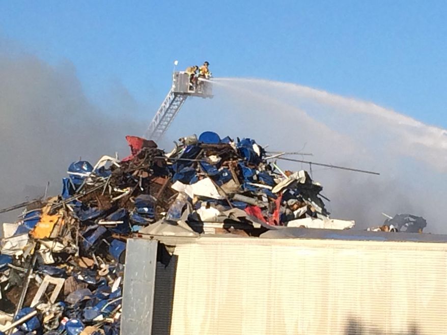 Walker firefighters spent spend hours putting out a scrap-metal fire at a Louis Padnos Iron & Metal facility in Walker, Mich., Friday, July 1, 2016. (John Tunison /The Grand Rapids Press via AP)