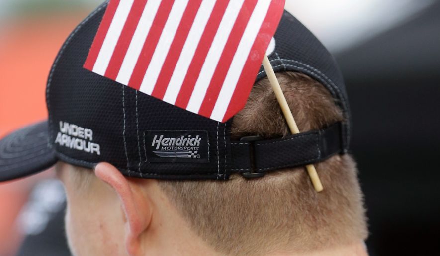 A member of Kasey Kahne&#39;s crew displays a U.S. flag in his hat band on pit road before the NASCAR Sprint Cup Series auto race at Daytona International Speedway, Saturday, July 2, 2016, in Daytona Beach, Fla. (AP Photo/John Raoux)