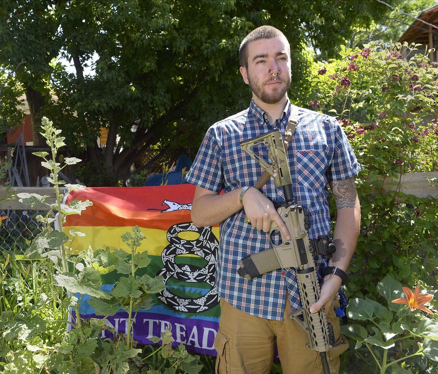 Matt Schlentz poses with his Rainbow-Gadsen Flag and AR-15 in his backyard in Salt Lake City, Wednesday, June 16. Schlentz is the Pink Pistols Utah chapter President and said Pink Pistols, a national LGBT pro-gun rights organization, membership has grown from 1,500 to 4,000 since Omar Mateen's June 12 rampage in Orlando, Fla. (Al Hartmann/The Salt Lake Tribune via AP)