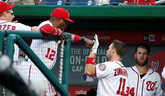 Washington Nationals manager Dusty Baker congratulates Ryan Zimmerman after the first baseman slugged a two-run home run in the fifth inning to give the team the cushion it needed in a 7-4 win over the Milwaukee Brewers on Wednesday. (Associated Press)