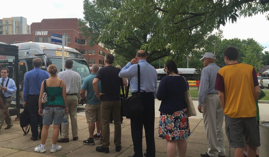 Wednesday marked the first morning rush hour commute of Phase Three with long lines that snaked from the Braddock Road station doors to the bus loading zones — but riders were not at a standstill. Metro workers said buses would arrive at 10-minute intervals, and the stream of buses was fairly constant. (Photographs by Aubri Juhasz/The Washington Times)