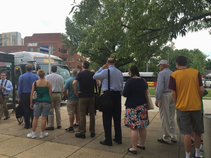 Wednesday marked the first morning rush hour commute of Phase Three with long lines that snaked from the Braddock Road station doors to the bus loading zones — but riders were not at a standstill. Metro workers said buses would arrive at 10-minute intervals, and the stream of buses was fairly constant. (Photographs by Aubri Juhasz/The Washington Times)