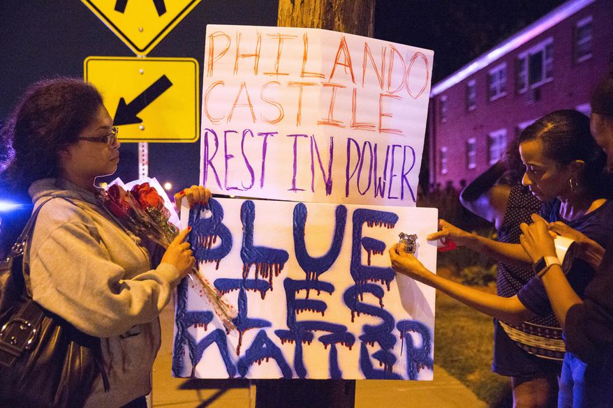 Protester's hang signs on a post near the scene of Philando Castile's shooting in Falcon Heights, Minn., Thursday, July 7, 2016. Castile was shot in a car Wednesday night in the largely middle-class St. Paul suburb of Falcon Heights. Police have said the incident began when an officer initiated a traffic stop in suburban Falcon Heights but have not further explained what led to the shooting. .(Leila Navidi/Star Tribune via AP) ** FILE **