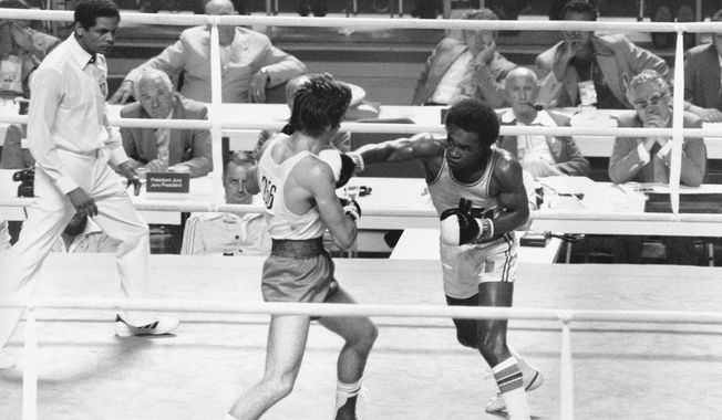 FILE - In this July 29, 1976, file phot, Sugar Ray Leonard of Palmer Park, Md., right, throws a right at Kazmier Szczerba of Poland during the light welterweight boxing match at the XXI Summer Olympic Games in Montreal, Quebec, Canada. (AP Photo/File)