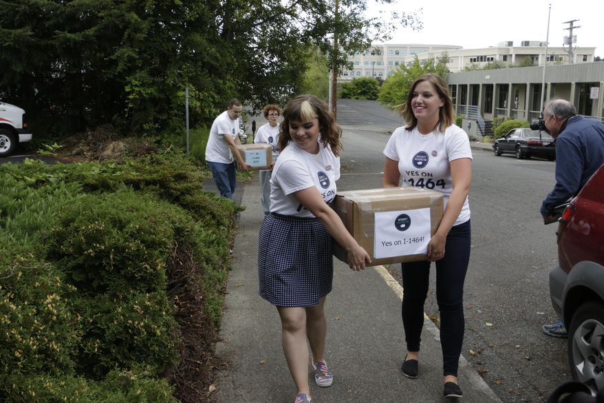 Supporters of a proposed campaign finance reform ballot measure carry boxes of signed petitions to turn in, on Friday, July 8, 2016, in Olympia, Wash. Initiative 1464 seeks to do several things, including creating a voucher system that would give voters three $50 "democracy credits" that they can use in state races every two years. (AP Photo/Rachel La Corte)