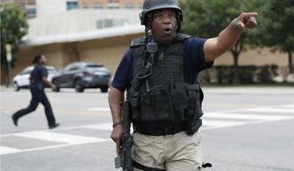 A Dallas police officer helps tighten security at their headquarters after receiving an anonymous threat against law enforcement across the city, Saturday, July 9, 2016, in Dallas. Five police were killed and several injured during a shooting in downtown Dallas Thursday night. (AP Photo/Eric Gay)