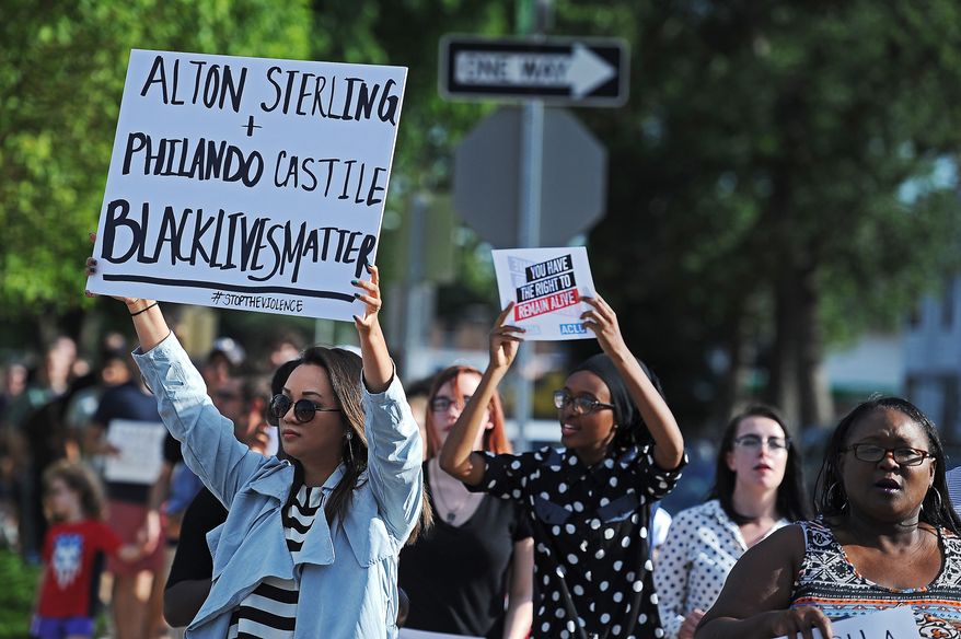 Lena Tran, of Vermillion, S.D., takes part in a Black Lives Matter vigil Saturday, July 9, 2016, in Sioux Falls, S.D., for Philando Castile, who was fatally shot during a traffic stop in Minnesota, and Alton Sterling by police in Baton Rouge, La. (Joe Ahlquist/The Argus Leader via AP)