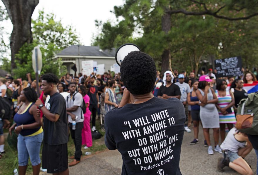 Protesters demonstrate a residential neighborhood in Baton Rouge, La. on Sunday, July 10, 2016. After an organized protest in downtown Baton Rouge protesters wandered into residential neighborhoods and toward a major highway that caused the police to respond by arresting protesters that refused to disperse. (AP Photo/Max Becherer)
