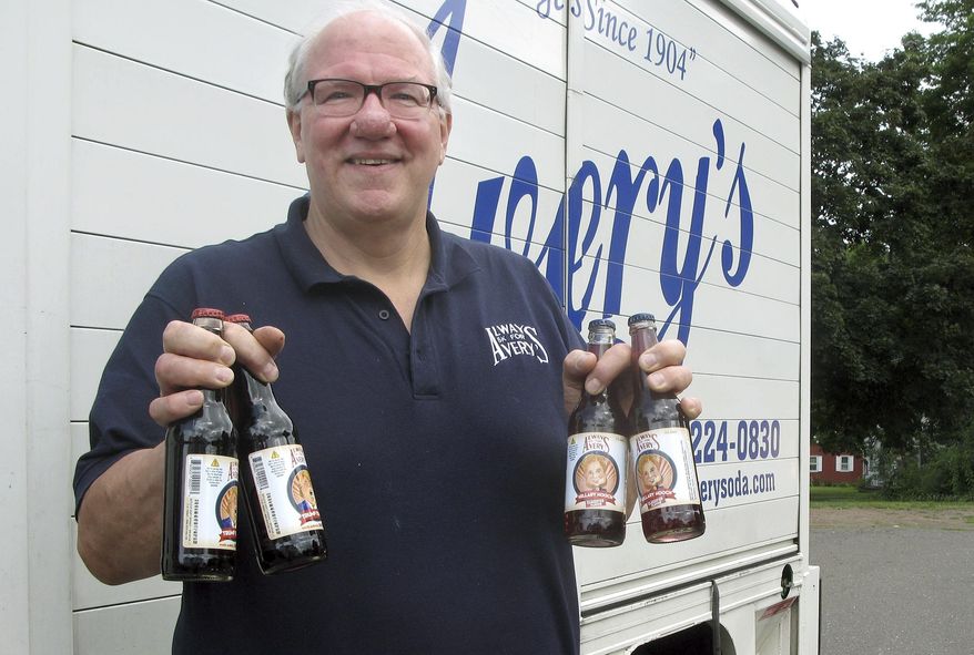Rob Metz, general manager of Avery's Beverages, holds samples of the company's latest specialty sodas, Hillary Hooch and Trump Tonic, outside the Avery's bottling facility, Monday, July 11, 2016, in New Britain, Conn. This is the third presidential race that company created candidate-based sodas and held a straw poll based on sales. During the last two cycles, Barack O'Berry beat John McCream and Cream de Mitt. (AP Photo/Pat Eaton-Robb)