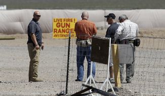 FILE - This Aug. 27, 2014 file photo shows people seen at the Last Stop outdoor shooting range in White Hills, Ariz. The girl who accidentally killed the shooting range instructor, Charles Vacca, in northern Arizona had said immediately after the shooting that she felt the gun was too much for her and had hurt her shoulder, according to police reports released Tuesday, Sept. 2, 2014. (AP Photo/John Locher, File)