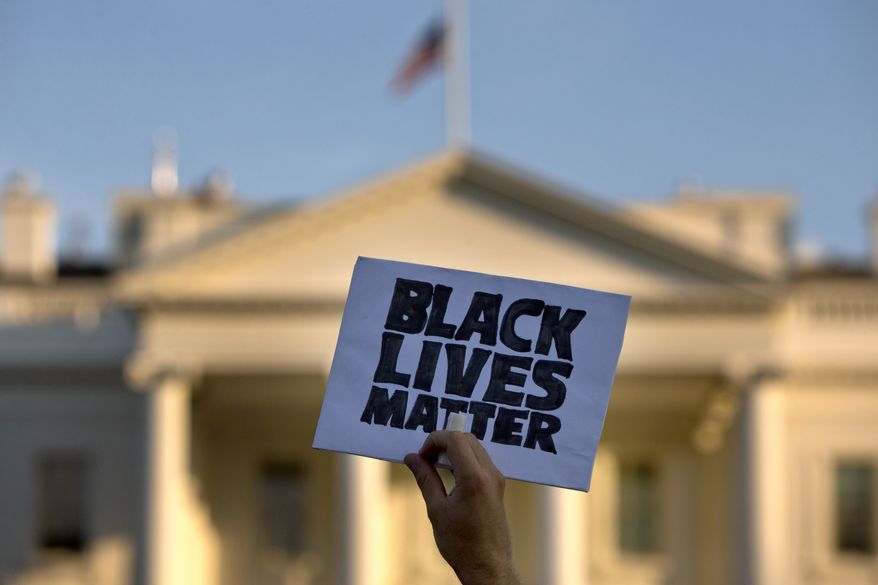 In this July 8, 2016, photo, a man holds up a sign saying &quot;black lives matter&quot; during a protest of shootings by police, in Washington by the White House. (AP Photo/Jacquelyn Martin) ** FILE **