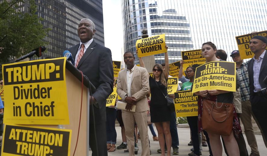 William McNary, left, with Citizen Action Illinois, speaks against Republican presidential candidate Donald Trump, next to the Chicago River across from the Trump International Hotel and Tower in Chicago, Tuesday, July 12, 2016. (AP Photo/Tae-Gyun Kim)