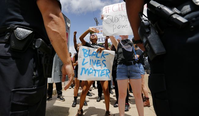 Protesters with the Black Lives Matter movement  argue with police to let them walk down the sidewalk during a rally outside Graceland on Elvis Presley Blvd Tuesday afternoon, July 12, 2016 in Memphis, Tenn.  Dozens of protesters associated with the Black Lives Matter movement demonstrated Tuesday outside the gates of Graceland, the former home of Elvis Presley. Police said four people were detained for blocking the street.  (Mike Brown/The Commercial Appeal via AP)