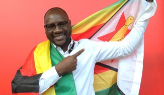 FILE - In this Tuesday May 3, 2016 file photo, shows Evans Mawarire, a young pastor, posing with a Zimbabwean flag in Harare, Zimbabwe. Zimbabwe police have charged Mawarire on Tuesday July 12, 2016, with inciting violence and disturbing the peace. (AP Photo/Tsvangirayi Mukwazhi, File)