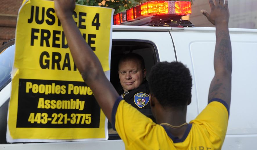 Melvin Townes, of Baltimore, stands with a &amp;quot;Justice 4 Freddie Gray&amp;quot; sign in front of a police officer during a protest Friday, July 8, 2016, in Baltimore. (Caitlin Few/The Baltimore Sun via AP)