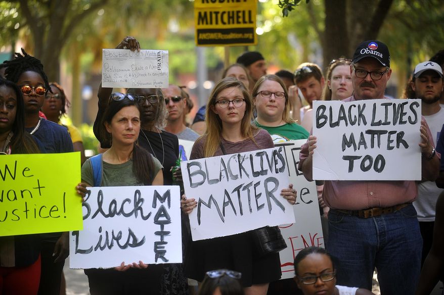 Protesters hold signs during a Black Lives Matter movement protest at Lykes Gaslight Park in downtown Tampa, Fla., Monday, July 11, 2016. (Octavio Jones/Tampa Bay Times via AP)