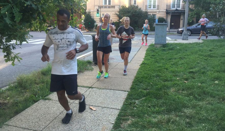 Runners round the corner of 15th and Euclid at Meridian Hills Park in the District only to stop and complete five burpees in the grass before continuing their November Project workout. Participants say it's positive reinforcement that keeps them going. (Emma Ann Patton/The Washington Times)