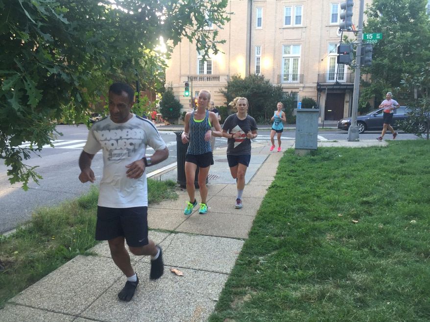 Runners round the corner of 15th and Euclid at Meridian Hills Park in the District only to stop and complete five burpees in the grass before continuing their November Project workout. Participants say it's positive reinforcement that keeps them going. (Emma Ann Patton/The Washington Times)
