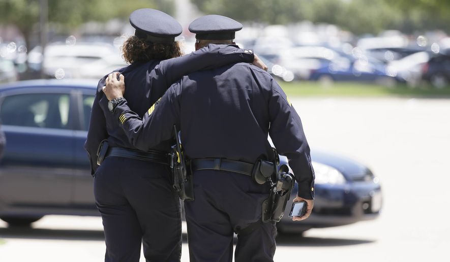 Dallas police officers comfort each other after the funeral services for Dallas Police Sr. Cpl. Lorne Ahrens at Prestonwood Baptist Church on Wednesday in Plano, Texas. (Associated Press)