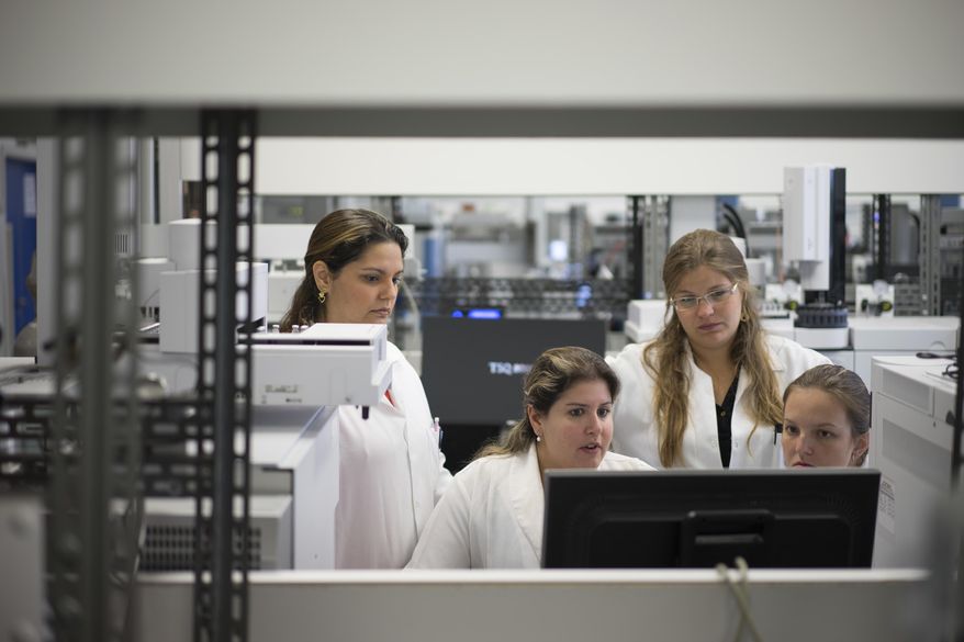 FILE - In this May 8, 2015 file photo, lab technicians work at the Brazilian Doping Control Laboratory (LBCD) before a visit by Brazil's sports minister in Rio de Janeiro, Brazil. The shuttered anti-doping laboratory for the Rio de Janeiro Olympics has been inspected by officials of the World Anti-Doping Agency, which could decide in late July 2016 if the laboratory gets re-accredited. The anti-doping laboratory was suspended in June 2016 for "nonconformity with International Standard for Laboratories." (AP Photo/Felipe Dana, File)