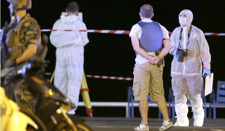 Forensic officers work at the scene of the truck attack that targeted Bastille Day revelers in Nice, France, on Friday. (Associated Press)