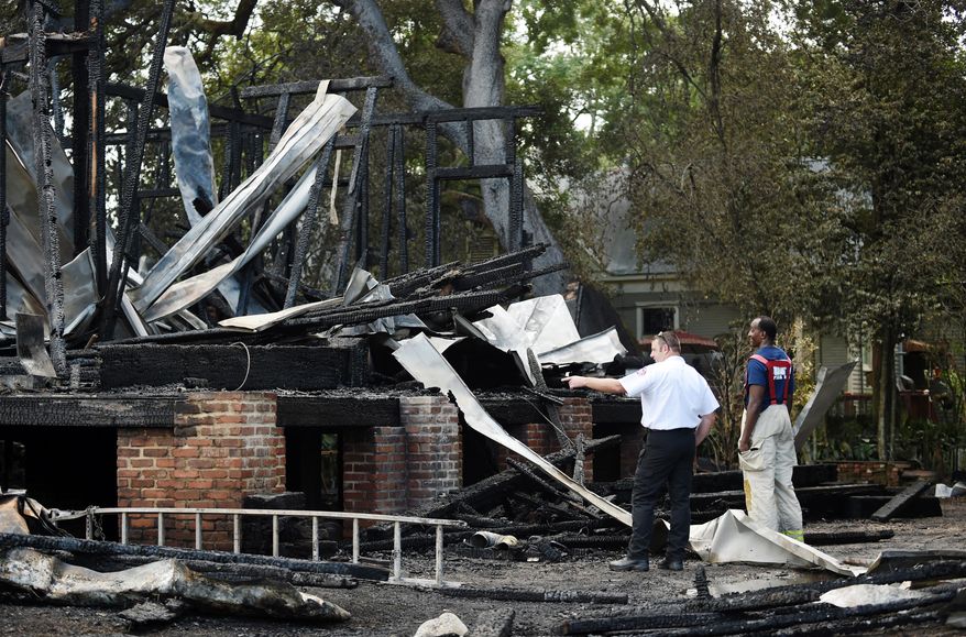 Opelousas Fire Chief Charles Mason, right, and Matt Rabalais, a training officer for St. Landry Fire Dist. 3, investigate the site of the old Governor's Mansion, in Opelousas, La., after the house was destroyed following a fire Thursday, July 14, 2016. Fire officials are still investigating the cause of the blaze. The house, which was under renovation, served as the Governor's Mansion for Gov. Thomas O. Moore during the Civil War in 1862 and 1863. (Leslie Westbrook/The Advocate via AP)
