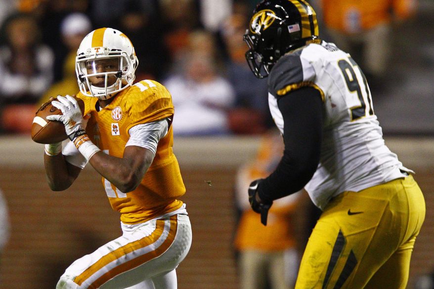 FILE - In this Nov. 22, 2014 file photo, Tennessee quarterback Joshua Dobbs (11) looks for a receiver as he's pressured by Missouri defensive lineman Josh Augusta (97) in the second half of an NCAA college football game in Knoxville, Tenn. No one player ever determines the fortunes of a team, although the quarterback is going to be important everywhere in the Southeastern Conference this season - except maybe Alabama. Six players, including Dobbs, will play a big role in determining how things shake out in the SEC. (AP Photo/Wade Payne, File)
